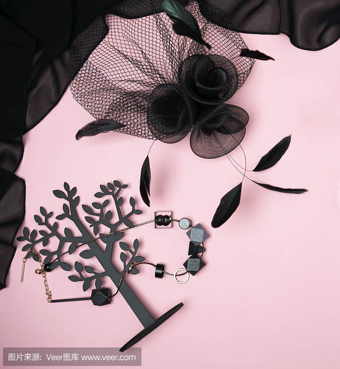 万圣节派对系列女性服装配件黑色在浅粉色的背景:珠宝,帽子与面纱和羽毛。平铺,俯视图,拷贝空间。“黑色星期五”的概念